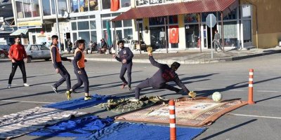 Sahası olmayan futbolcular, asfalta kilim serip antrenman yapıyor