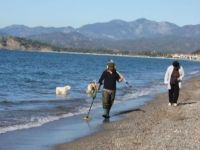 Fethiye'de bir kişi fırtına sonrası plajda dedektörle altın arıyor