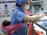 Hemşire ameliyatına katıldığı hastanın bebeğini sırtında taşıdı